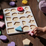 Montessori-style toy puzzles, on a playmat with a toddler playing
