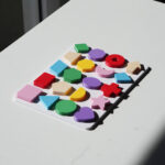Geometric shapes puzzle for toddlers – scattered and completed pieces shown to support shape recognition, spatial skills, and hands-on learning.
