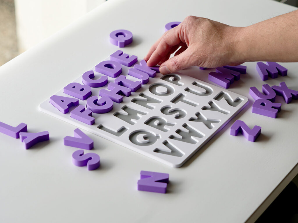 Uppercase alphabet puzzle with letters being placed – interactive learning toy supporting preschool literacy and fine motor skills.